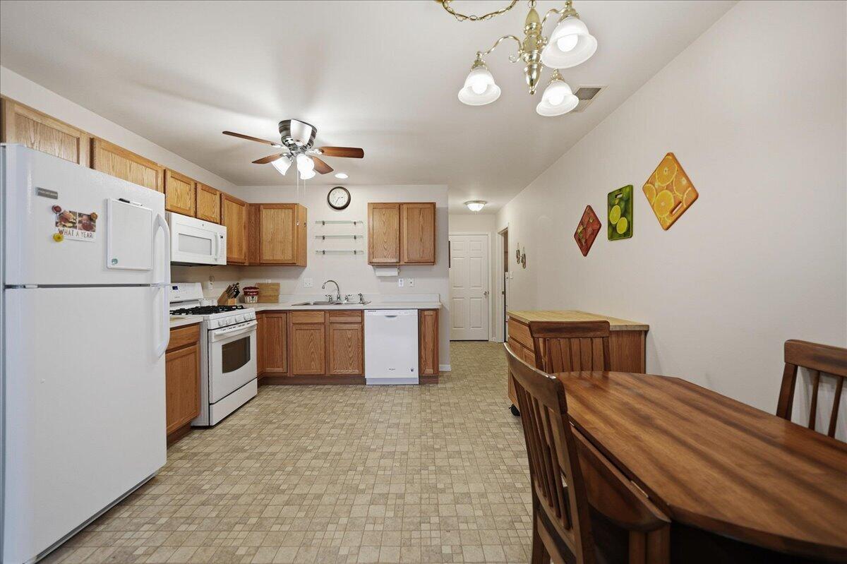 352 West 43rd Court Griffith, IN 46319 - Photo 6 of 19 a kitchen with stainless steel appliances granite countertop a stove a refrigerator a oven a sink a dining table and chairs with wooden floor