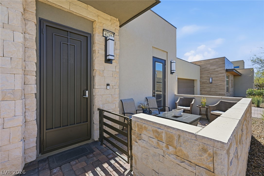 4246 Swift Street Las Vegas, NV 89135 - Photo 6 of 71 Entrance to property featuring a patio, stucco siding, and stone siding