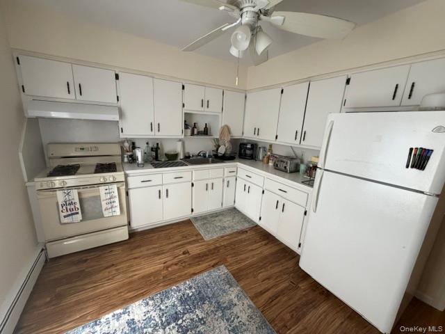 191 Birch Hill Road, Unit 3 Locust Valley, NY 11560 - Photo 5 of 15 Kitchen featuring wood-finish flooring, white cabinetry with black hardware, white countertops, and a ceiling fan with integrated lighting
