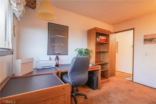 a view of a workspace with furniture and a window