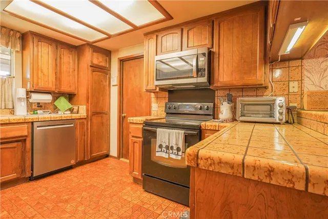 a kitchen with stainless steel appliances a stove microwave and cabinets