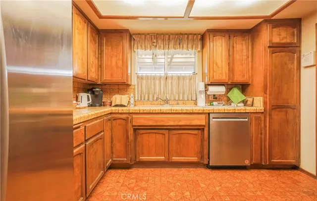 a kitchen with stainless steel appliances a refrigerator sink and cabinets
