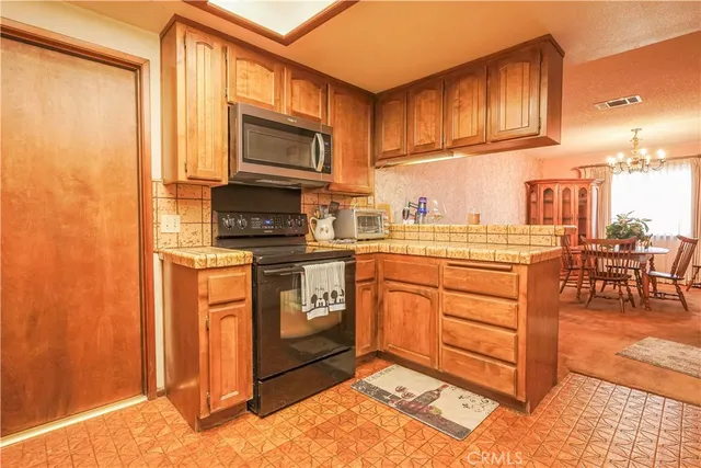 a kitchen with stainless steel appliances granite countertop a stove a sink and a microwave