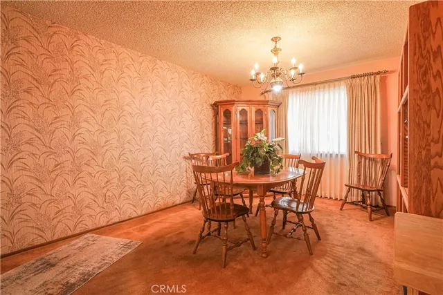 a view of a dining room with furniture and a chandelier