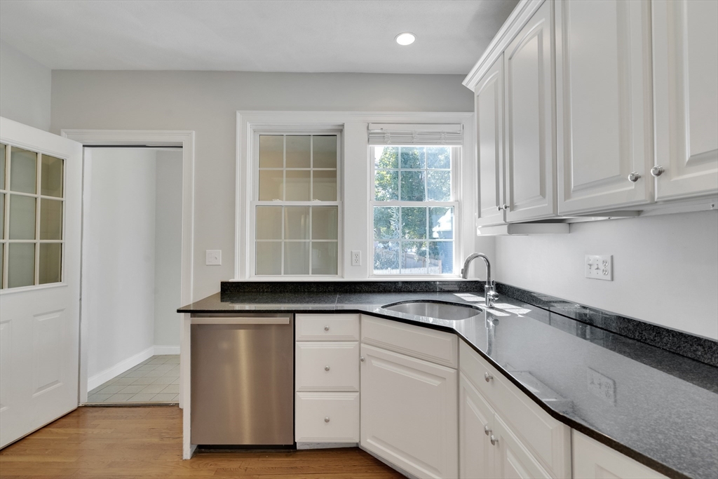 66 Webster Street, Unit 66 Newton, MA 02465 - Photo 12 of 40 a kitchen with granite countertop white cabinets and a sink