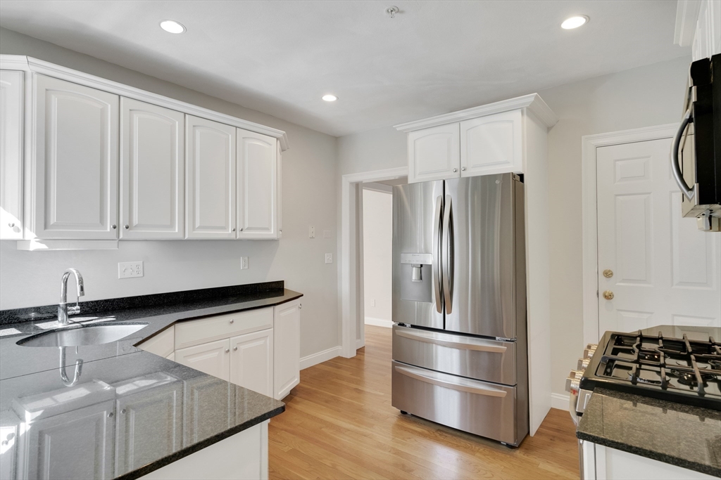 66 Webster Street, Unit 66 Newton, MA 02465 - Photo 14 of 40 a kitchen with stainless steel appliances granite countertop a refrigerator and a sink