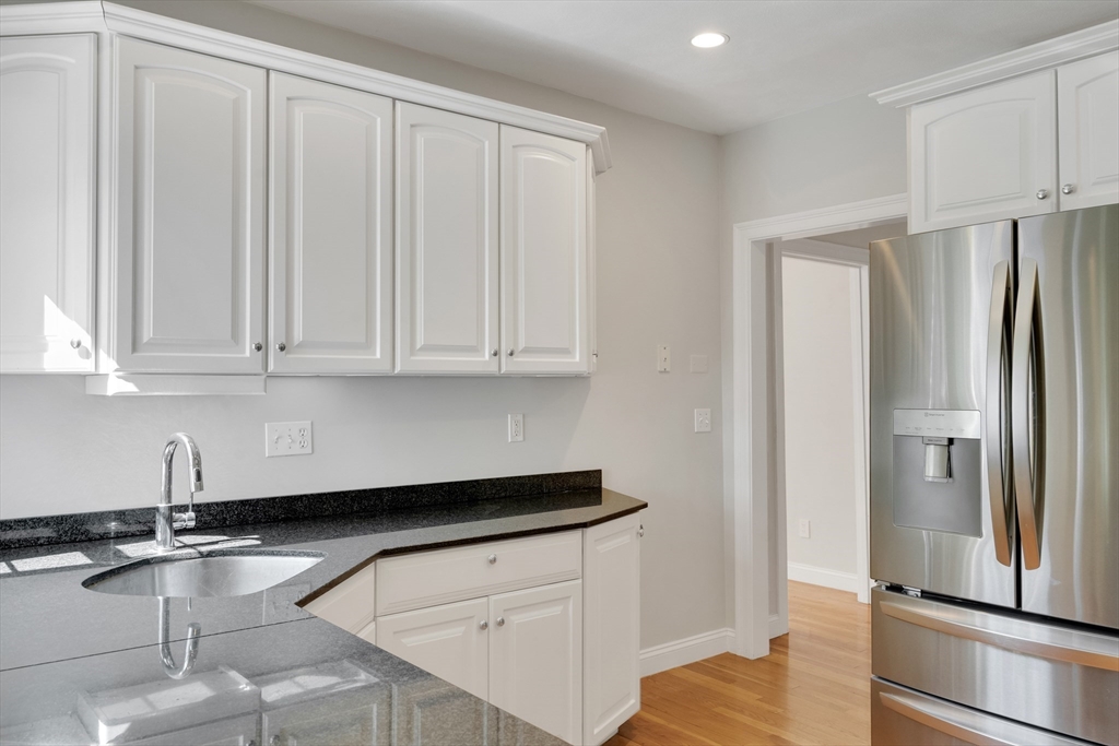 66 Webster Street, Unit 66 Newton, MA 02465 - Photo 15 of 40 a kitchen with granite countertop a refrigerator sink and cabinets