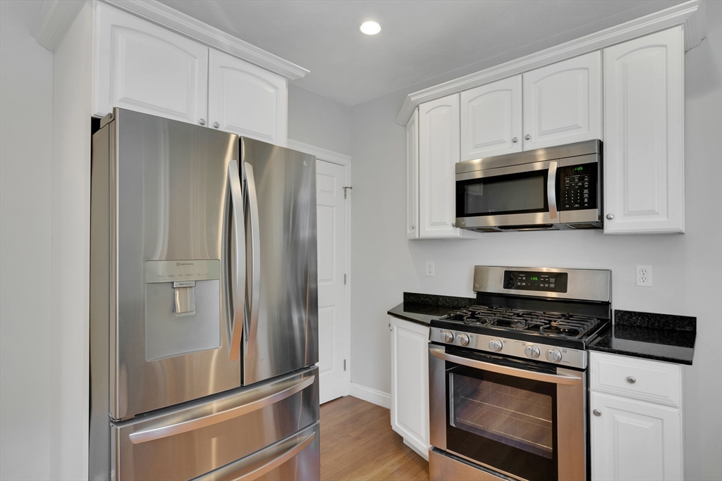 66 Webster Street, Unit 66 Newton, MA 02465 - Photo 16 of 40 a kitchen with stainless steel appliances a refrigerator stove and microwave