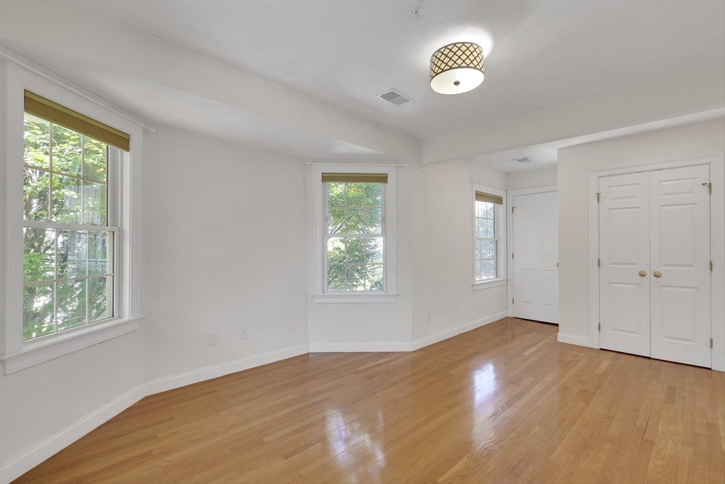 66 Webster Street, Unit 66 Newton, MA 02465 - Photo 24 of 40 a view of an empty room with a window and wooden floor