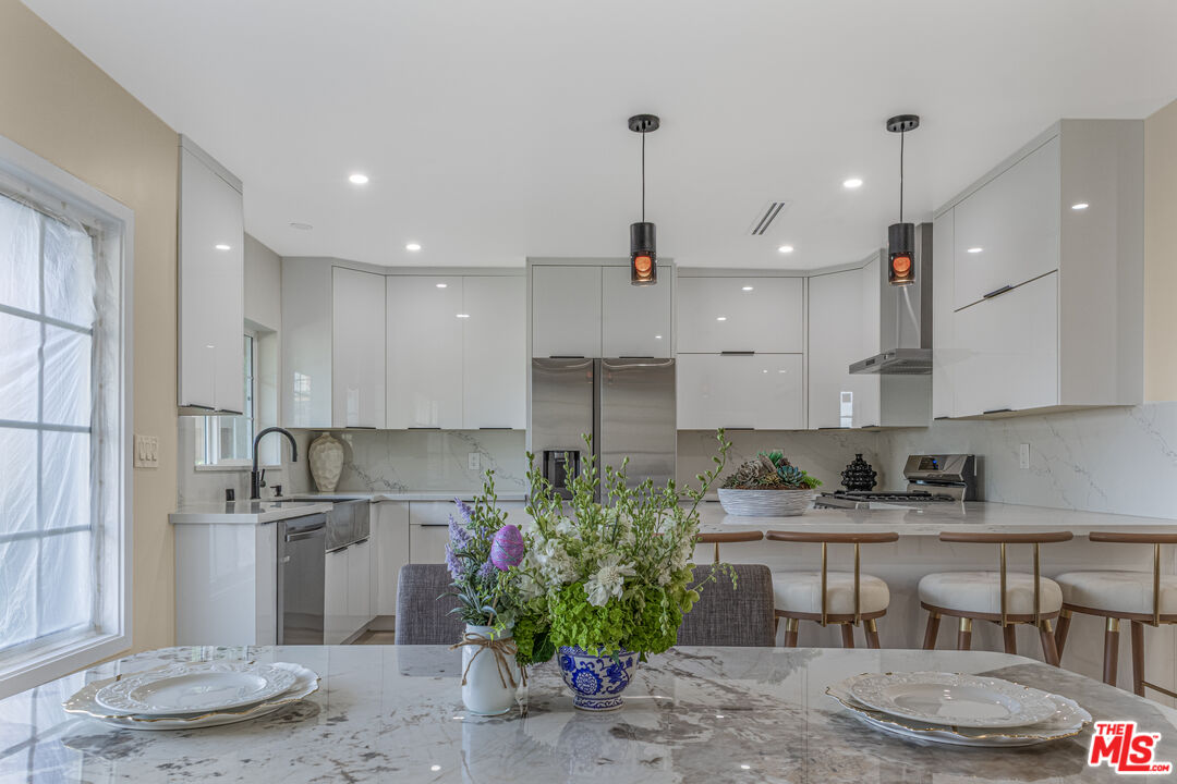 3500 Tuller Avenue Los Angeles, CA 90034 - Photo 5 of 20 a kitchen with kitchen island granite countertop a sink a stove a refrigerator and a cabinets