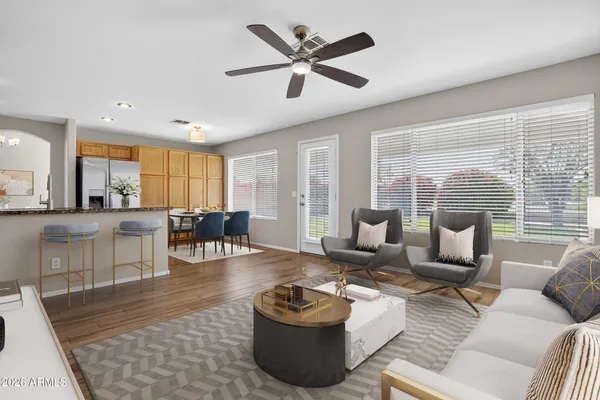 a kitchen with stainless steel appliances granite countertop a refrigerator a stove a sink cabinets and a wooden floor