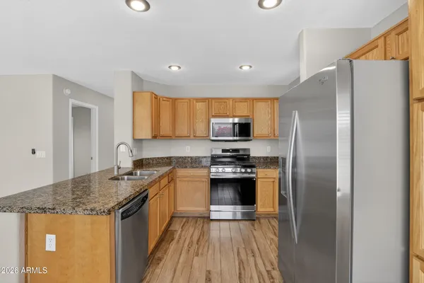 an empty room with chandelier fan and windows