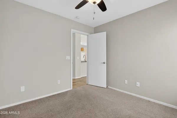 an empty room with a window and a fan