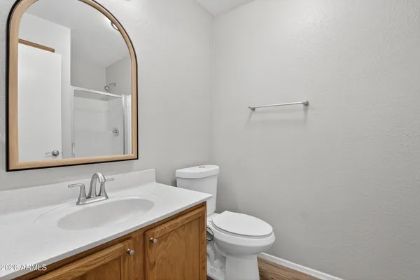 a bathroom with a granite countertop sink toilet a mirror and shower