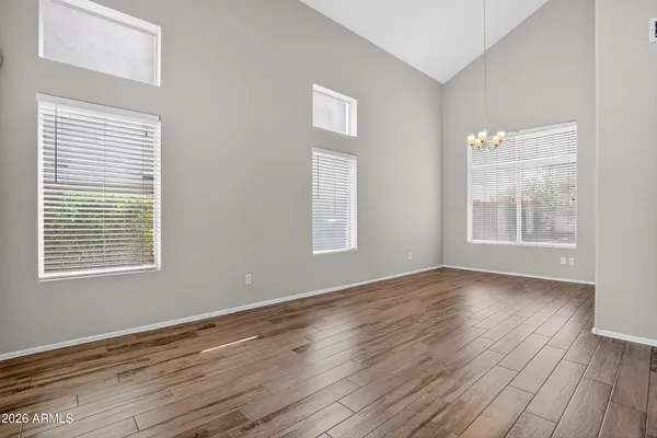 a view of a big room with wooden floor and a kitchen