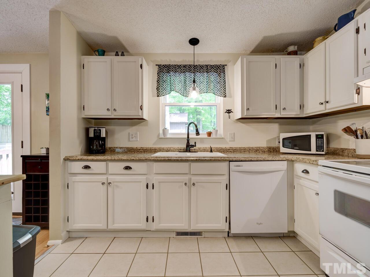 7249 Mine Shaft Road Raleigh, NC 27615 - Photo 12 of 45 a kitchen with white cabinets white appliances and sink