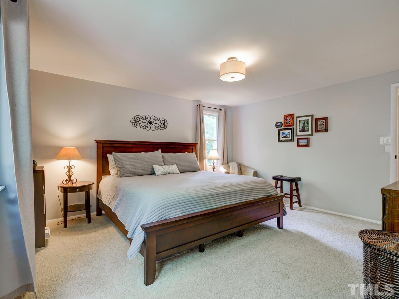 7249 Mine Shaft Road Raleigh, NC 27615 - Photo 18 of 45 a spacious bedroom with a bed and a table in it