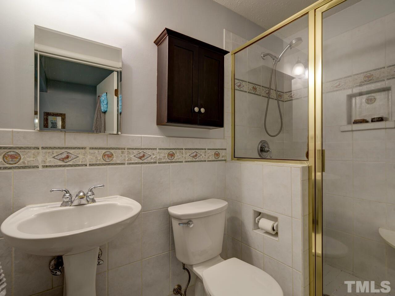 7249 Mine Shaft Road Raleigh, NC 27615 - Photo 21 of 45 a bathroom with a sink a toilet and mirror