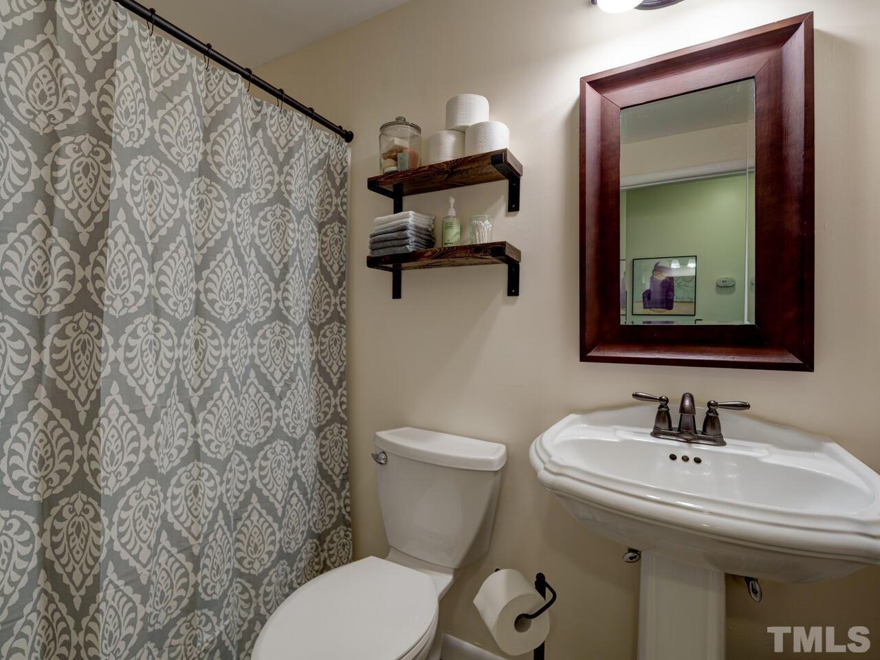 7249 Mine Shaft Road Raleigh, NC 27615 - Photo 28 of 45 a bathroom with a toilet sink and mirror