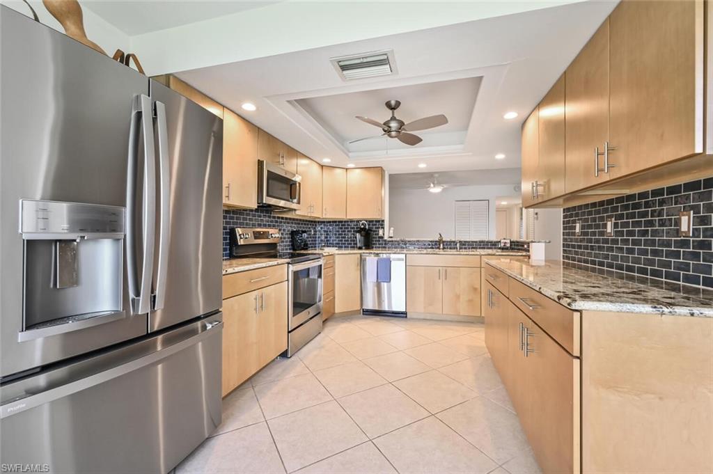 492 Veranda Way, Unit E105 Naples, FL 34104 - Photo 12 of 34 a large kitchen with cabinets and stainless steel appliances