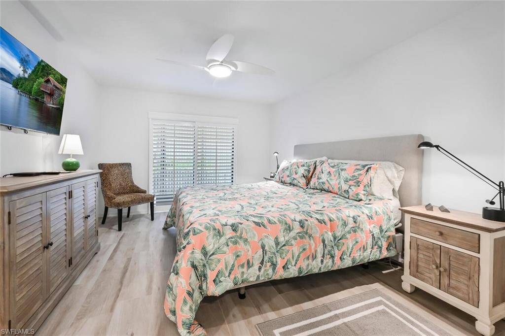 492 Veranda Way, Unit E105 Naples, FL 34104 - Photo 13 of 34 a bedroom with a bed and a flat screen tv