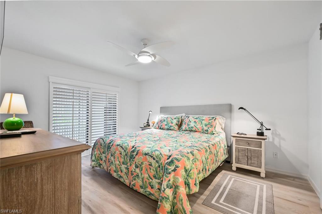 492 Veranda Way, Unit E105 Naples, FL 34104 - Photo 14 of 34 a bedroom with a large bed and a chandelier