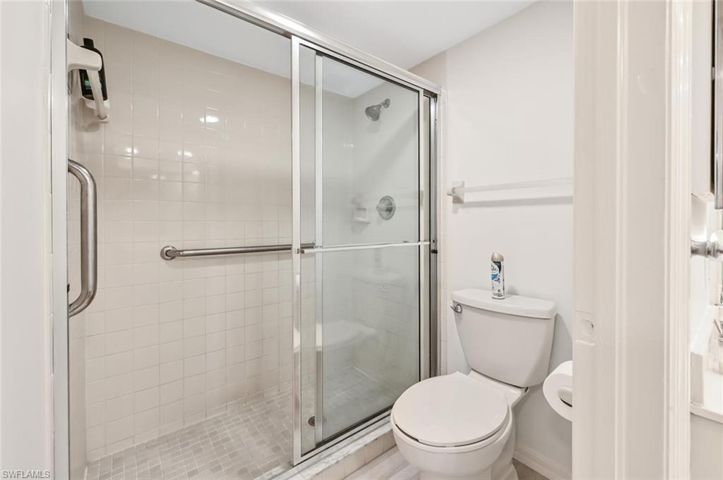 492 Veranda Way, Unit E105 Naples, FL 34104 - Photo 16 of 34 a white toilet next to a bathroom