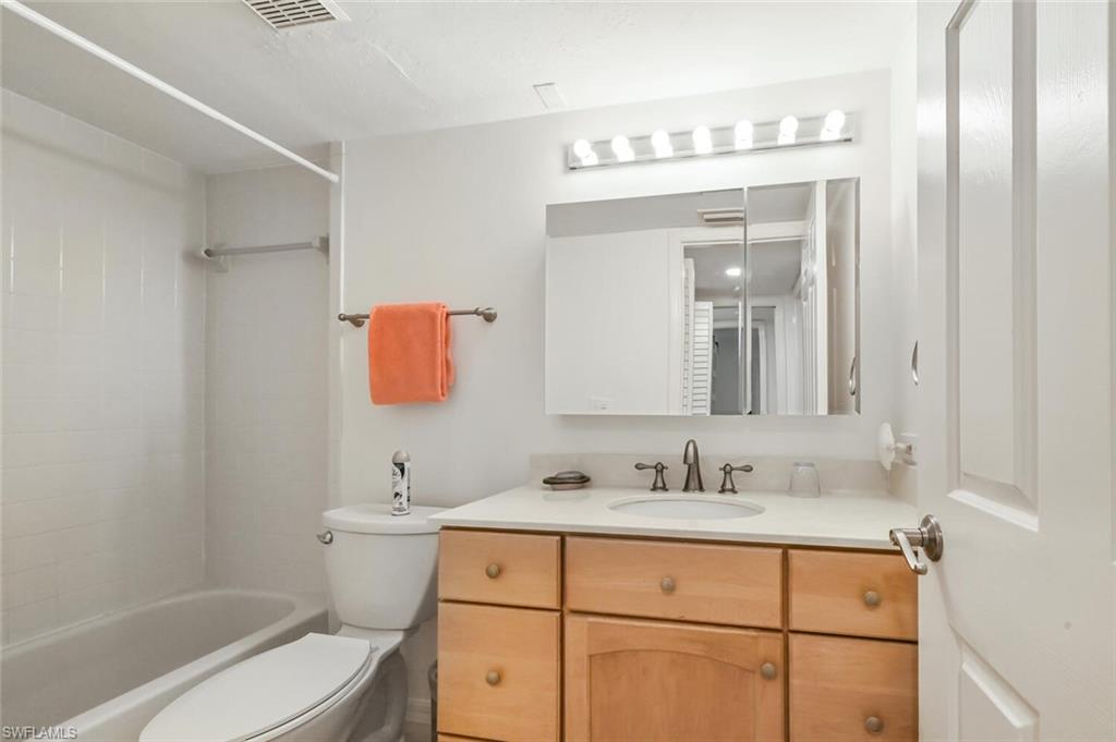 492 Veranda Way, Unit E105 Naples, FL 34104 - Photo 18 of 34 a bathroom with a sink vanity mirror and toilet