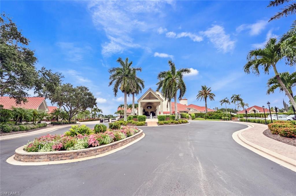 492 Veranda Way, Unit E105 Naples, FL 34104 - Photo 23 of 34 a view of a swimming pool with a yard and palm trees