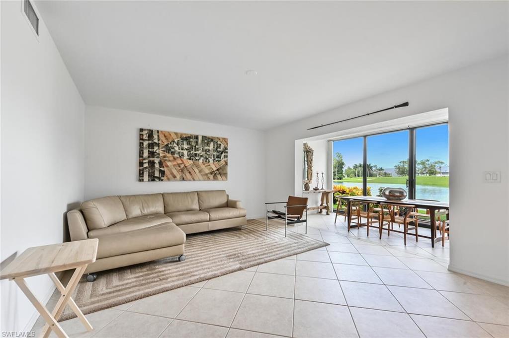492 Veranda Way, Unit E105 Naples, FL 34104 - Photo 5 of 34 a living room with furniture and a large window