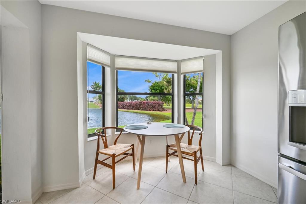 492 Veranda Way, Unit E105 Naples, FL 34104 - Photo 6 of 34 a view of a dining room with furniture large windows and wooden floor