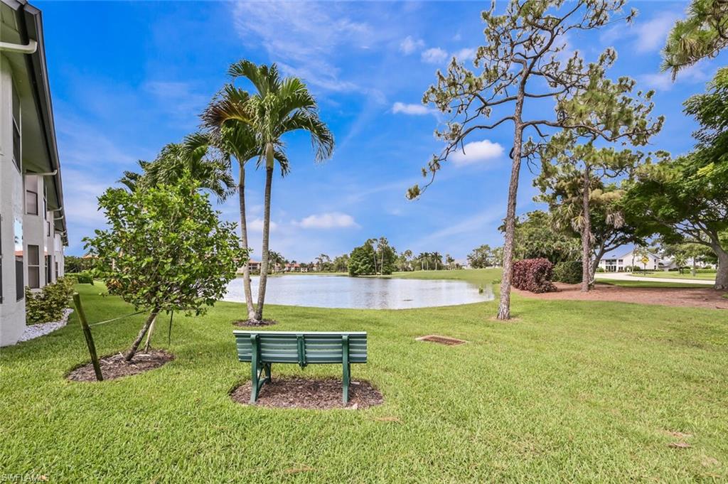 492 Veranda Way, Unit E105 Naples, FL 34104 - Photo 9 of 34 a garden with a bench and some trees