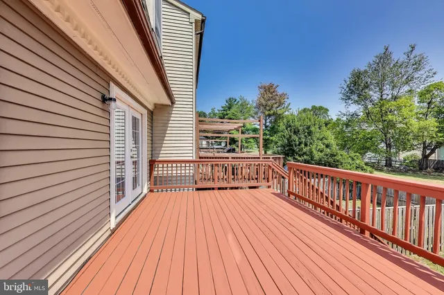 a view of balcony with wooden floor and fence and a potted plant