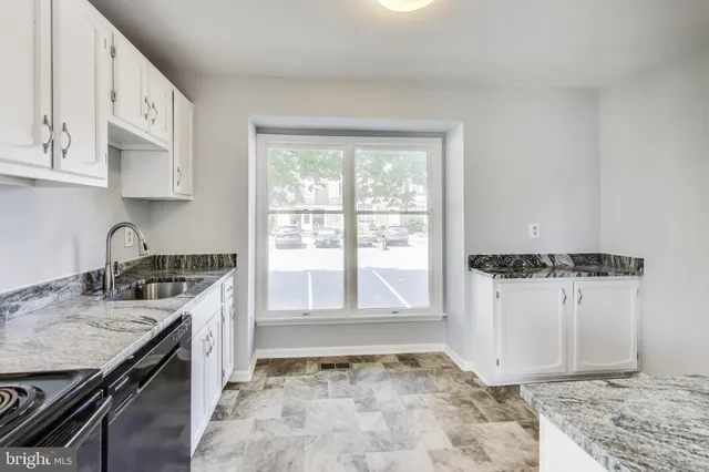 a view of a kitchen with a sink stove and cabinets