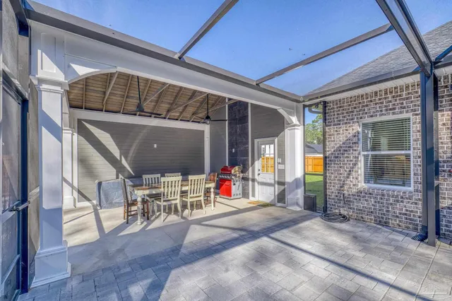 a backyard of a house with chairs and wooden fence