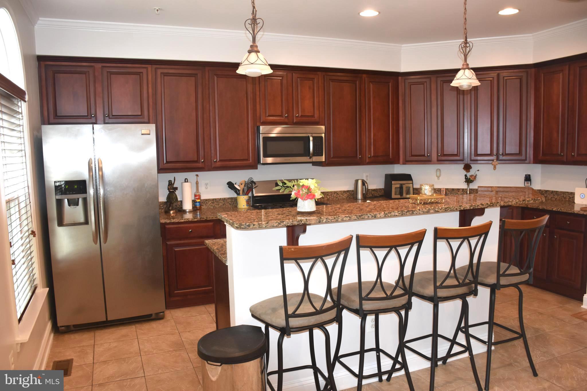 803 Ryan Street Baltimore, MD 21230 - Photo 16 of 41 a kitchen with stainless steel appliances granite countertop a refrigerator a stove a sink and chairs