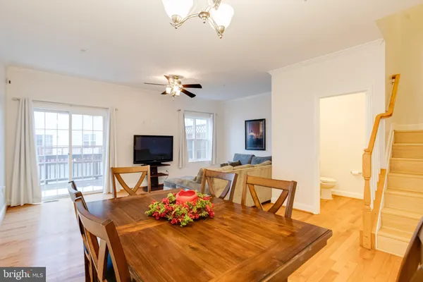 a kitchen with stainless steel appliances granite countertop wooden cabinets a stove a sink a dining table and chairs