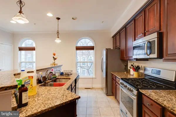 a kitchen with stainless steel appliances granite countertop a stove a refrigerator a oven a sink with a dining table and chairs