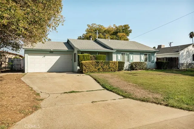 a front view of a house with a yard and potted plants