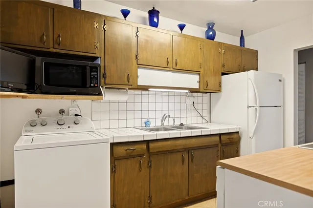 a utility room with cabinets washer and dryer