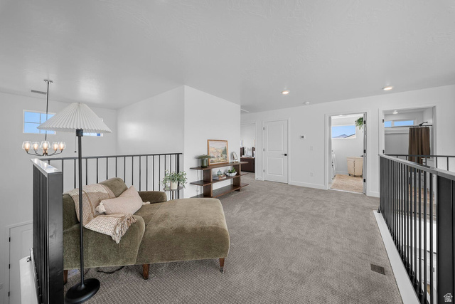 382 North Rhyolite Drive, Unit 111 Hurricane, UT 84737 - Photo 19 of 37 Spacious upper-level landing featuring plush gray carpeting, white walls, and contemporary black metal railings