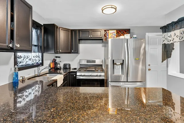 a kitchen with granite countertop a refrigerator and a sink
