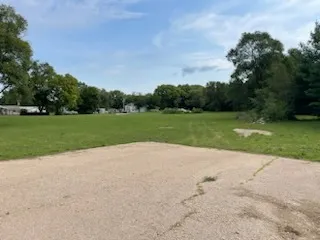 a view of a field and trees in the background