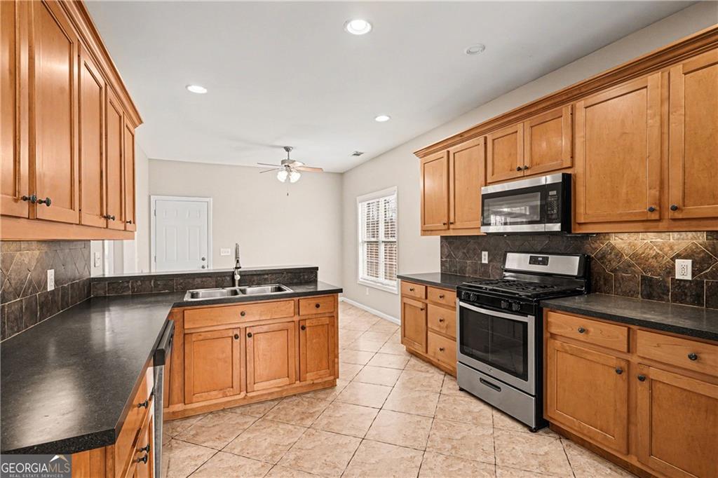 159 Sable Trace Trail Acworth, GA 30102 - Photo 11 of 40 a kitchen with stainless steel appliances granite countertop a stove top oven a sink dishwasher a dining table and chairs with wooden floor