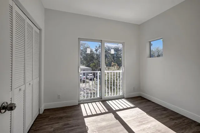 a view of a room with wooden floor and a window