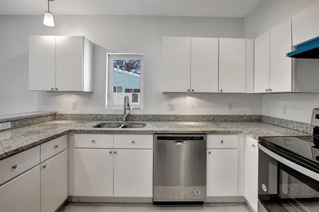 a kitchen with granite countertop white cabinets and a stainless steel appliances