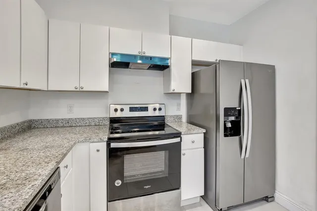 a kitchen with stainless steel appliances granite countertop a refrigerator sink and cabinets