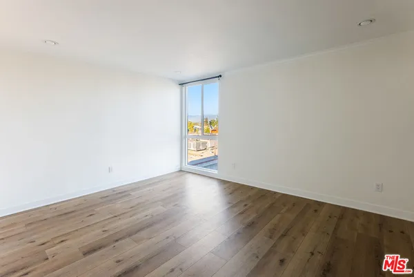 a view of an empty room and wooden floor