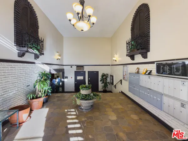 a hallway with a flower pot and a bookshelf
