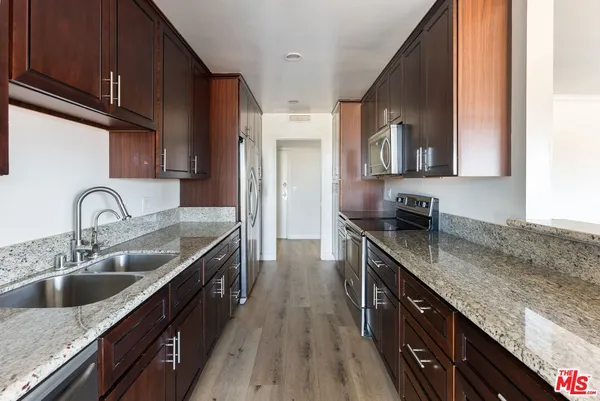 a kitchen with stainless steel appliances granite countertop a sink stove and cabinets